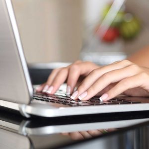 Woman hands working with a laptop at home