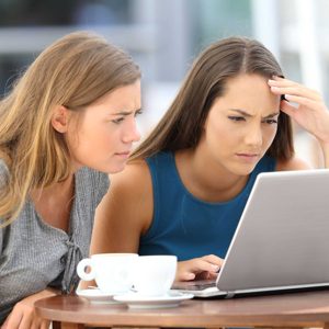 Two worried friends watching media content on line