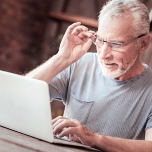 Close up of elderly man with a laptop
