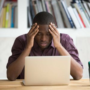 Frustrated black man feeling depressed after fail sitting with l