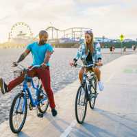 couple having fun riding bikes together at santa monica california