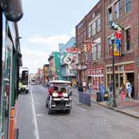 NASHVILLE, TN, USA - APRIL 14, 2017: Nashville's historic Broadway street, home to Ernest Tubb Record Shop, noisy and full of bars, entertainment, country music and visited by countless tourists on foot, in golf carts or busses.